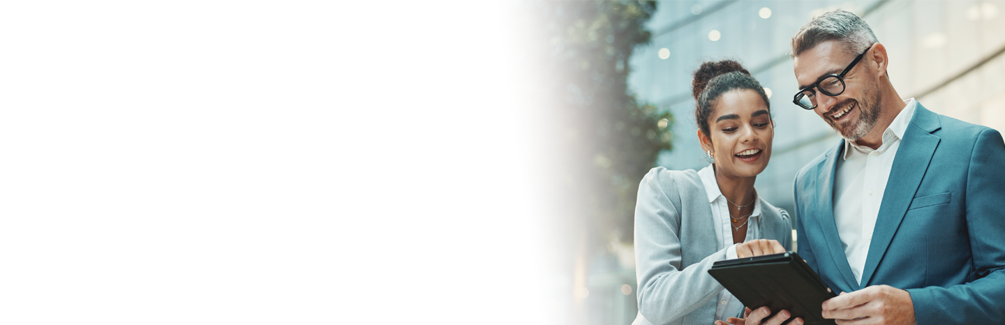 Young woman working on a table outside with senior man