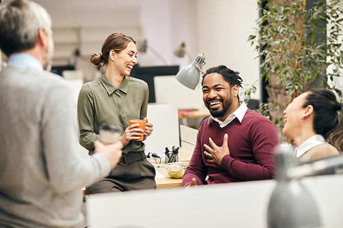 Diverse group of coworkers talking and drinking coffee