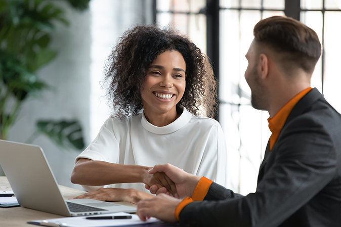 Smiling African American businesswoman advisor broker shaking client customer hand at meeting, making great deal after successful negotiations, executive mentor greeting new worker intern