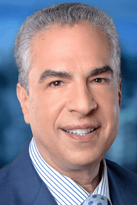 Professional headshot of a man wearing a blue suit and striped shirt